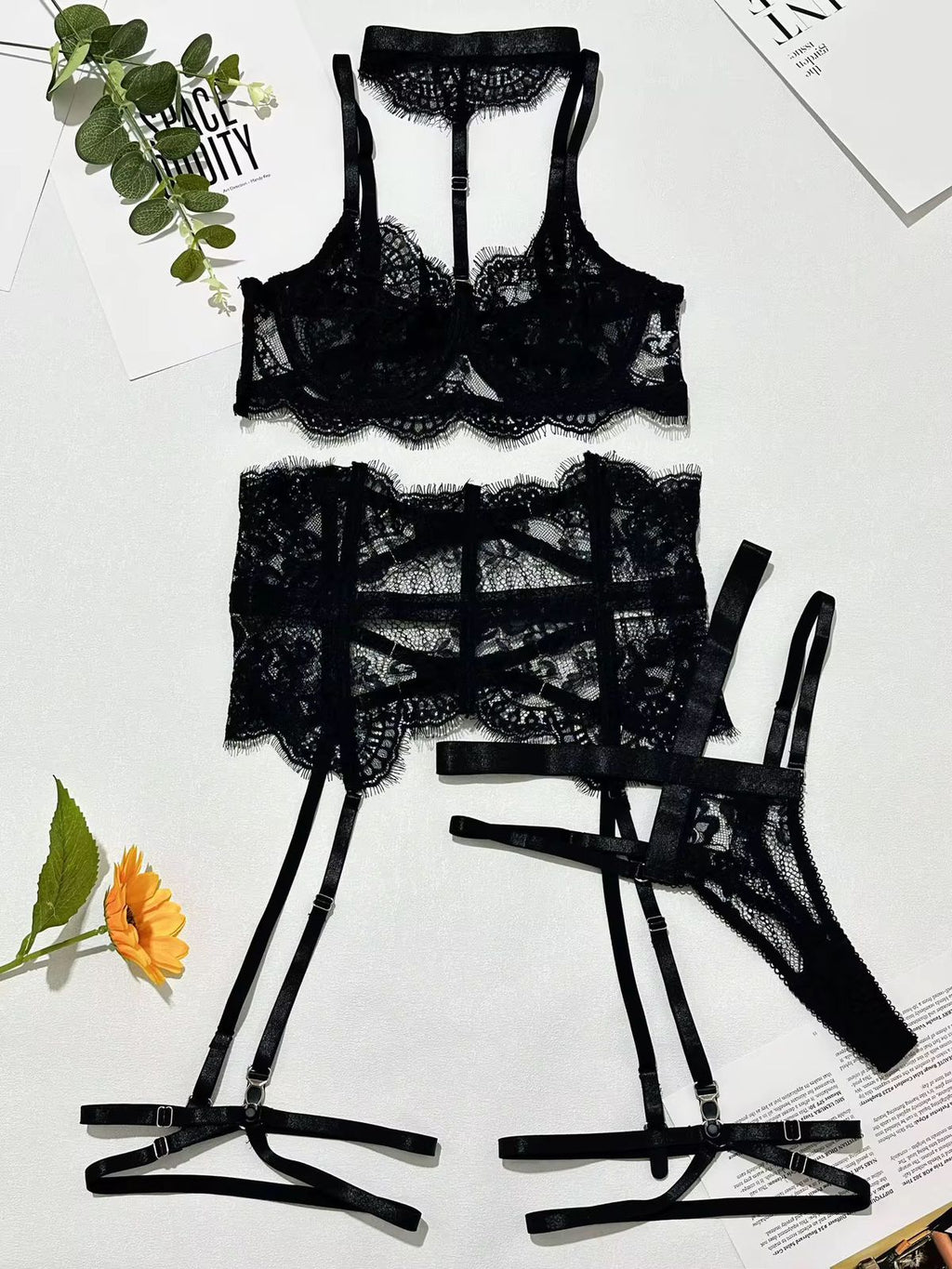 Black lace lingerie set on a light background with floral decorations