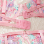 Pink lingerie set with floral mesh design on a white background