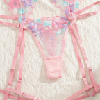 Pink lingerie set with floral details on a textured white background