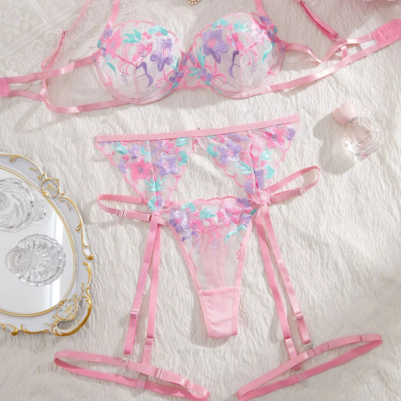 Floral lingerie set with pink straps on a textured surface