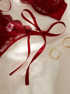 Red lace lingerie with a red ribbon on a beige background