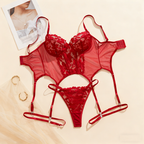 Red lace lingerie set on a beige surface with a magazine and gold ring.