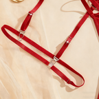 Red lingerie straps with metal hooks on a beige fabric background
