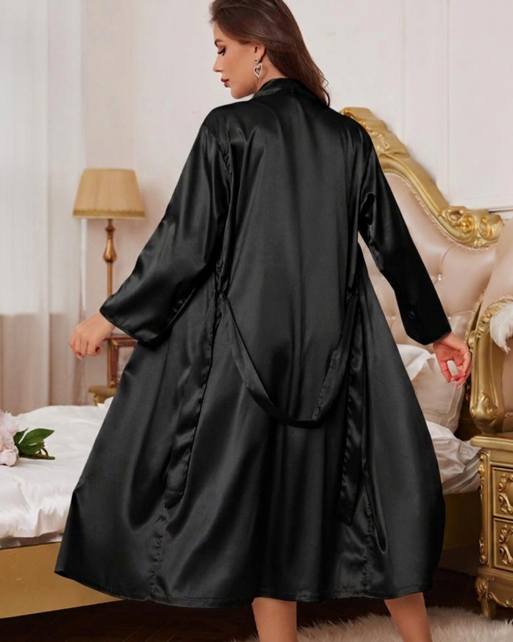 Woman wearing a black satin robe in a bedroom setting