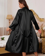 Woman wearing a black satin robe in a bedroom setting